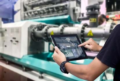 Hands holding tablet on blurred automation machine inside smart factory