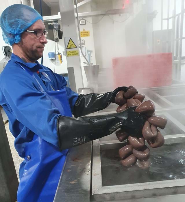 Maker at The Bury Black Pudding Company steaming produce