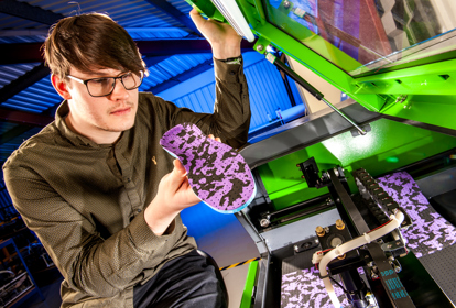 Man inspecting an insole created from a 3D printer
