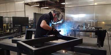 Fabricator welding steel frame at Abbey Group