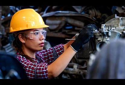 Female Engineer working with machine in factory.