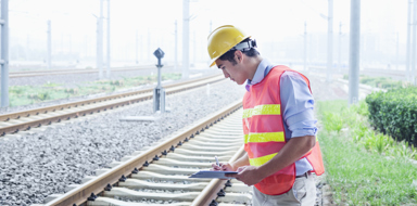 Railroad worker in protective work wear checking the railroad tracks