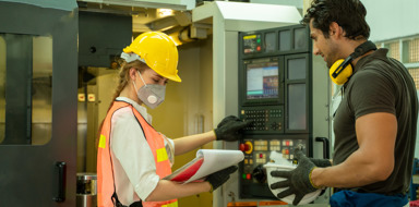 Factory worker wearing protective mask to Protect Against Covid-19,Technician working and checking machine in a large industrial factory