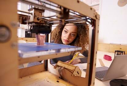 Female Designer Working With 3D Printer In Design Studio