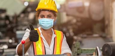 Female factory worker wears a disposable face mask for protection of Corona Virus Spreading and smoke dust air pollution filter in a factory.