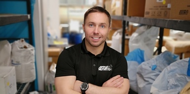 Senior leader at Applied Nutrition stood in factory looking at the camera