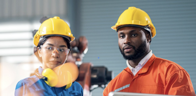 UK manufacturing diversity & inclusion guide - A man and a woman with construction hats working on a manufacturing facility.