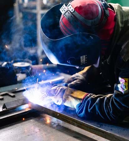 Industrial engineer using blow torch to weld metal work