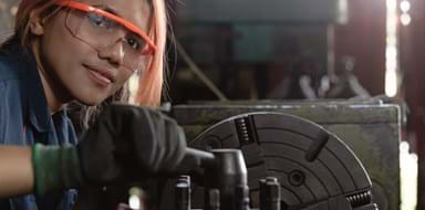 Certified industry female mechanical engineer working on industrial factory machinery - Skilled apprentice technician woman wearing safety equipment