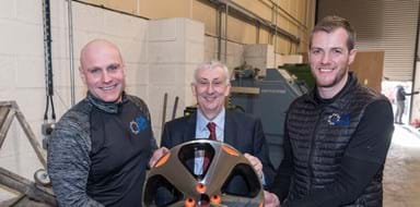 Management Team from DA Techs smiling at the camera with alloy wheel in hand