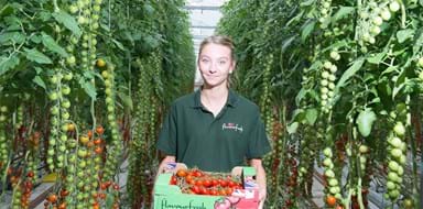 Member of staff looking at camera holding produce at Flavourfresh Salads